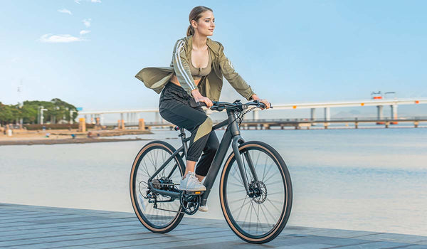 Woman riding electric bike by lake