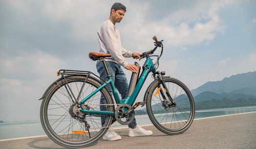 A man is removing the battery from a Fiido C11 pro lightweight electric bicycle.