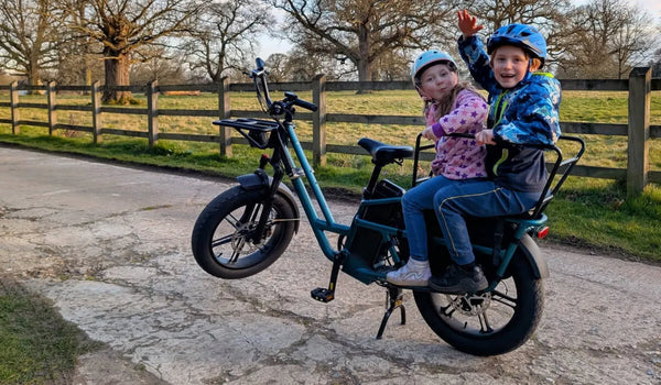 Two children are riding on a Fiido T2 two-seater electric bike.