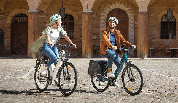A man and a woman are riding a Fiido C11 City e-bike on a gravel road.