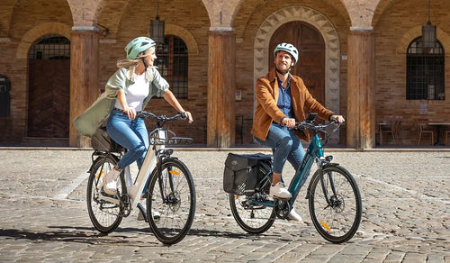 A man and a woman are riding a Fiido C11 City e-bike on a gravel road.