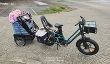A Fiido T2 cargo e-bike is shown fully loaded with a child seat, side panniers, a front cargo box, and a heavily packed rear trailer.