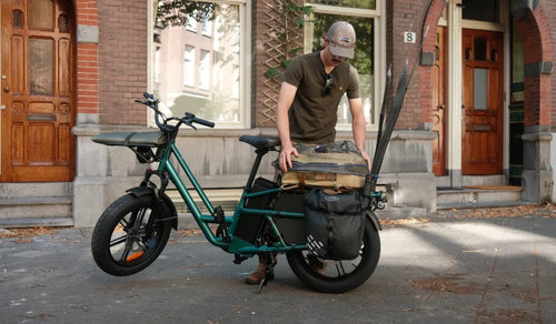 A man rides a Fiido T2 cargo e-bike to go fishing outdoors.