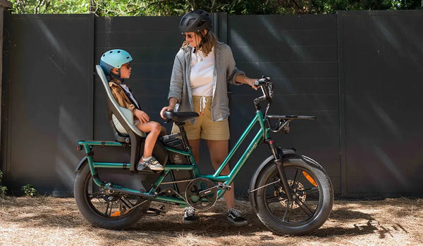 A woman uses a Fiido T2 electric bicycle with a rear-mounted child seat.