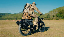 A man prepares to hunt in the wilderness on a Fiido Titan electric bicycle.