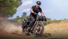 A man speeds through the mountains on a Fiido Titan fat-tire bicycle.