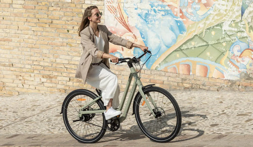 A woman rides a Fiido C700 electric bicycle on the street.