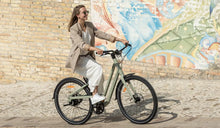 A woman rides a Fiido C700 electric bicycle on the street.